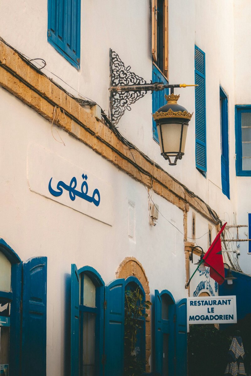 Blue Arabic lettering painted on a white wall, After