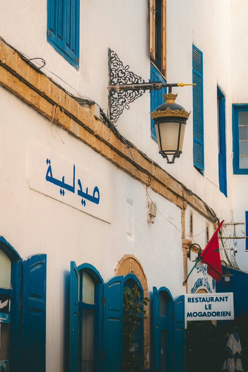 Blue Arabic lettering painted on a white wall, Before