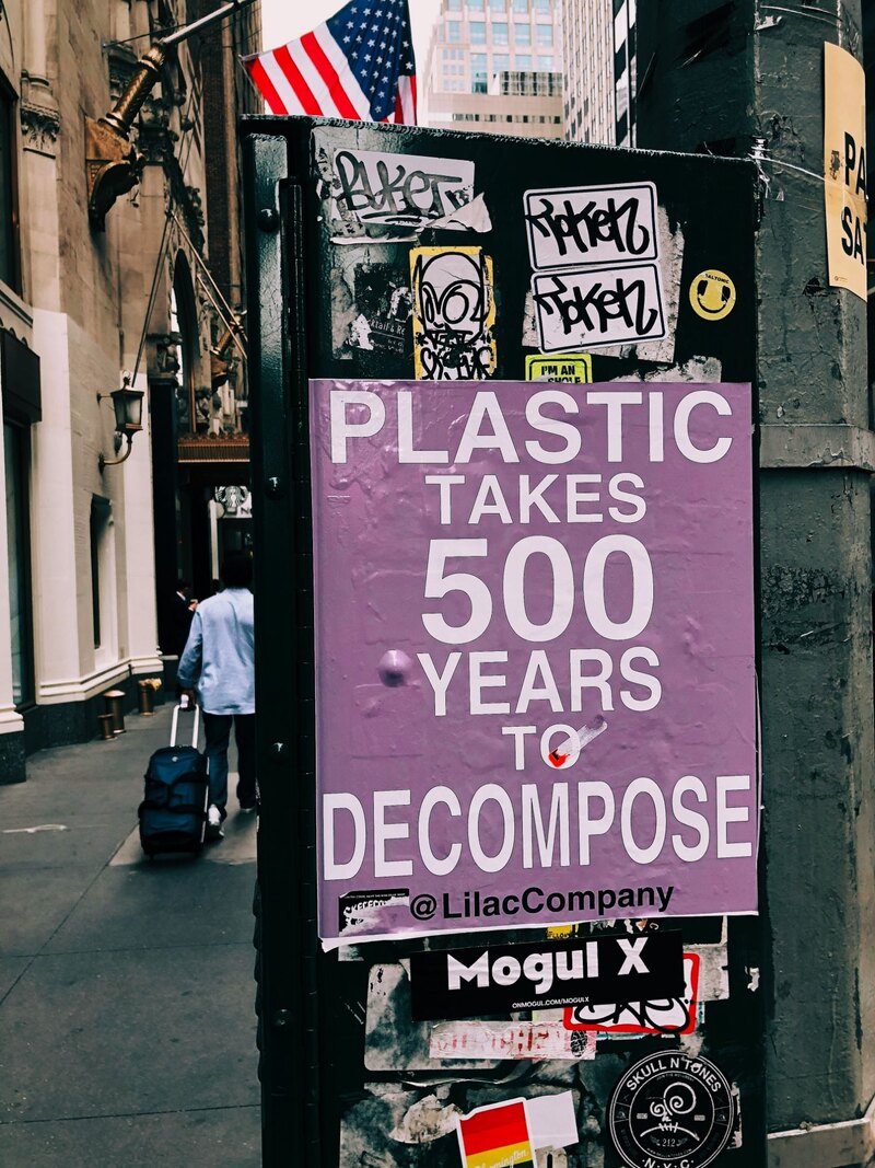 A purple street poster that says Plastic takes 500 years to decompose, Before