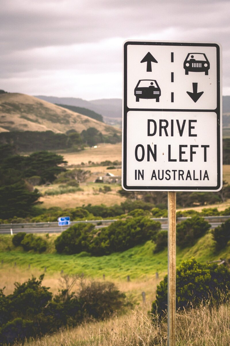A Drive on left in Australia road sign in green hills, Before